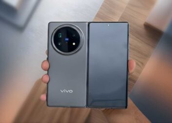 A hand holding the upcoming Vivo X Fold 6 showing its large circular camera module with a city background.